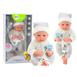 Baby doll in white and gray striped clothes, hat, pacifier, quilt