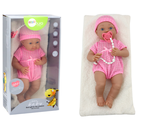 Baby doll in pink clothes, hat, pacifier, and blanket